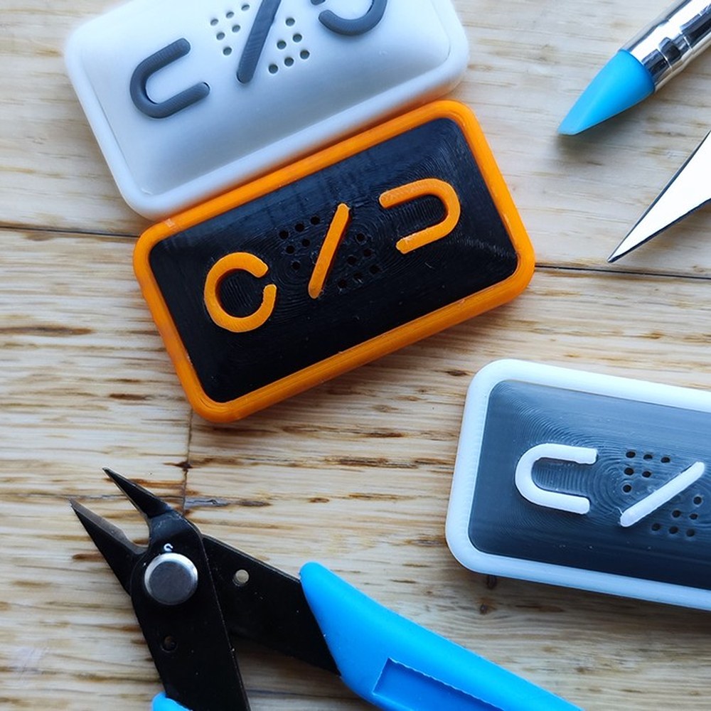 Three 3D-printed ONU form studies on a workbench with cutting tools